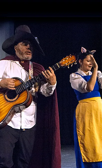Omar y Sandra San Lucas, durante una interpretación de canción con guitarra en la obra teatral infantil Copérnico, el gato con botas, por La Carpa de la Luna, en Guayaquil, Ecuador