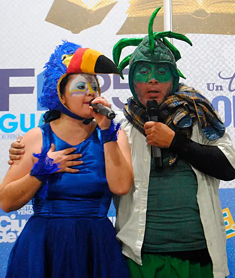 Sandra San Lucas interpretando al personaje de el Tucán, y Omar San Lucas en el personaje de la Iguana, en el contexto de la obra teatral La Iguana, el tucán y el delfín desaparecido, durante una actividad del proyecto Vive Palabras de San Lucas Cultura, en Guayaquil, Ecuador
